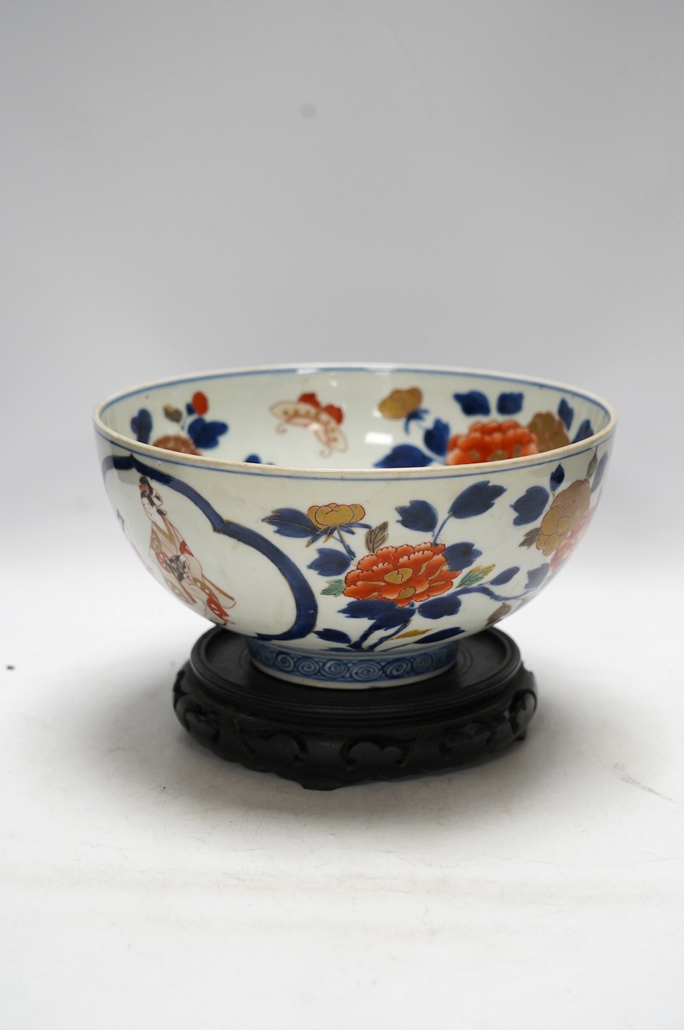 A Japanese Arita polychrome bowl, c.1700, diameter 24.5cm, height 12.5cm, on a carved hardwood stand. Condition - large overglazed open firing crack to foot, otherwise good